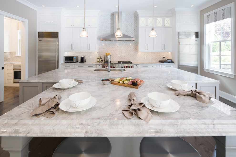 This is an example of a large traditional single-wall kitchen in Philadelphia with flat-panel cabinets, white cabinets, granite benchtops, white splashback, stainless steel appliances and with island.