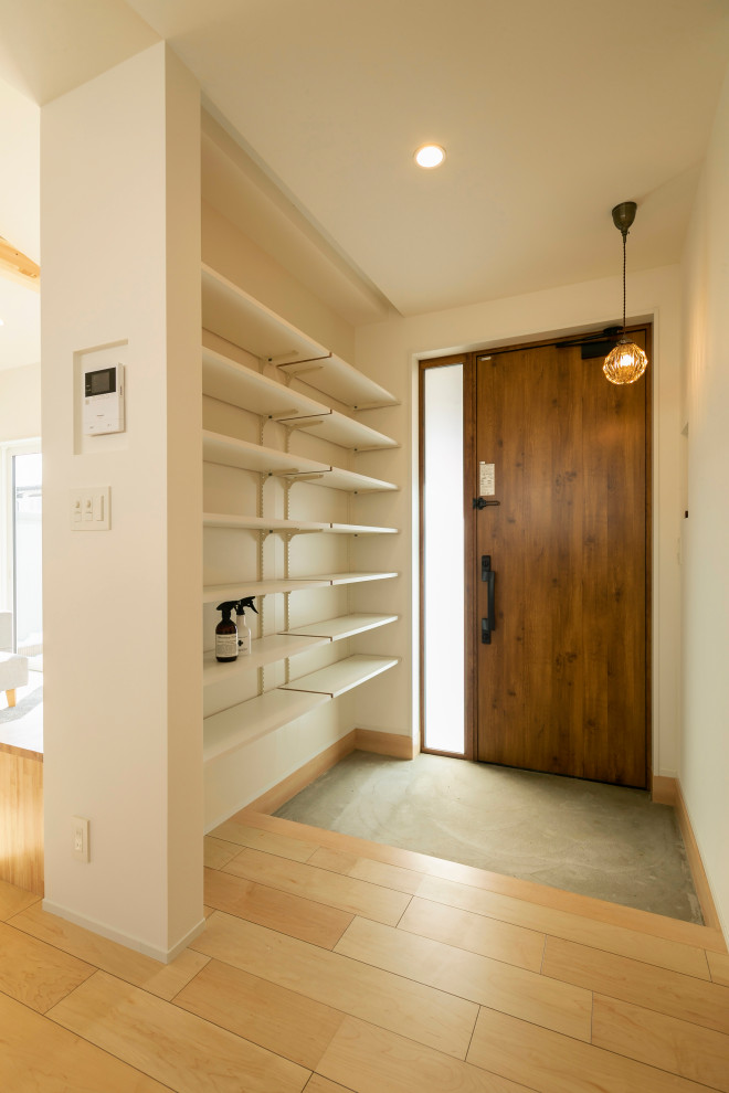 Idéer för en mellanstor minimalistisk hall, med vita väggar, mellanmörkt trägolv, en enkeldörr, mellanmörk trädörr och brunt golv