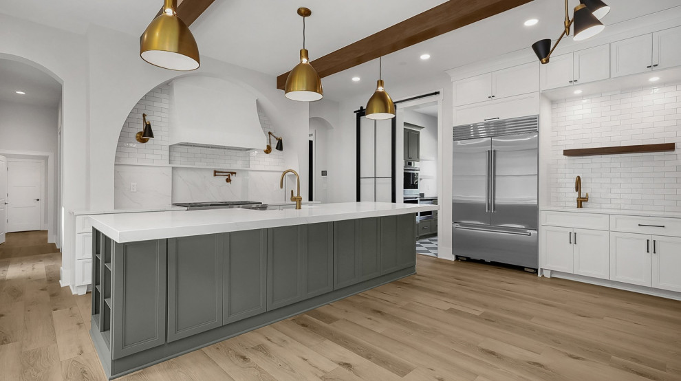 Transitional u-shaped vinyl floor and exposed beam kitchen pantry photo in Columbus with shaker cabinets, white cabinets, quartz countertops, white backsplash, subway tile backsplash, an island, white countertops, a farmhouse sink and stainless steel appliances