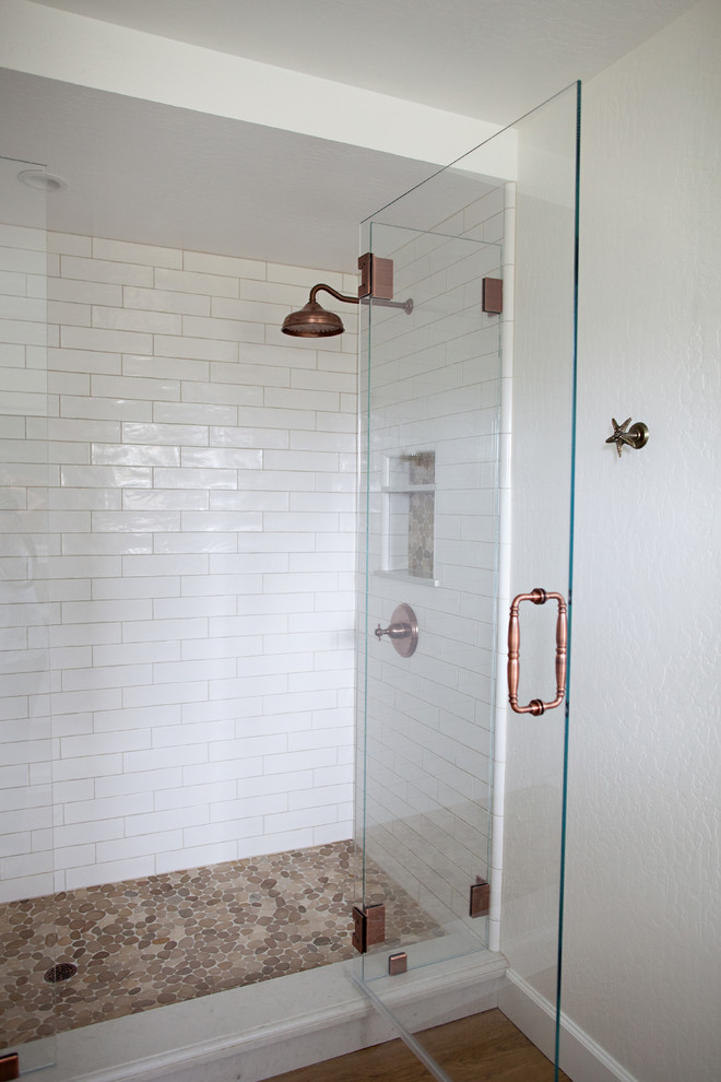 Inspiration for a mid-sized beach style 3/4 bathroom in San Francisco with recessed-panel cabinets, white cabinets, an alcove shower, a two-piece toilet, beige tile, gray tile, multi-coloured tile, mosaic tile, white walls, dark hardwood floors, a drop-in sink and engineered quartz benchtops.