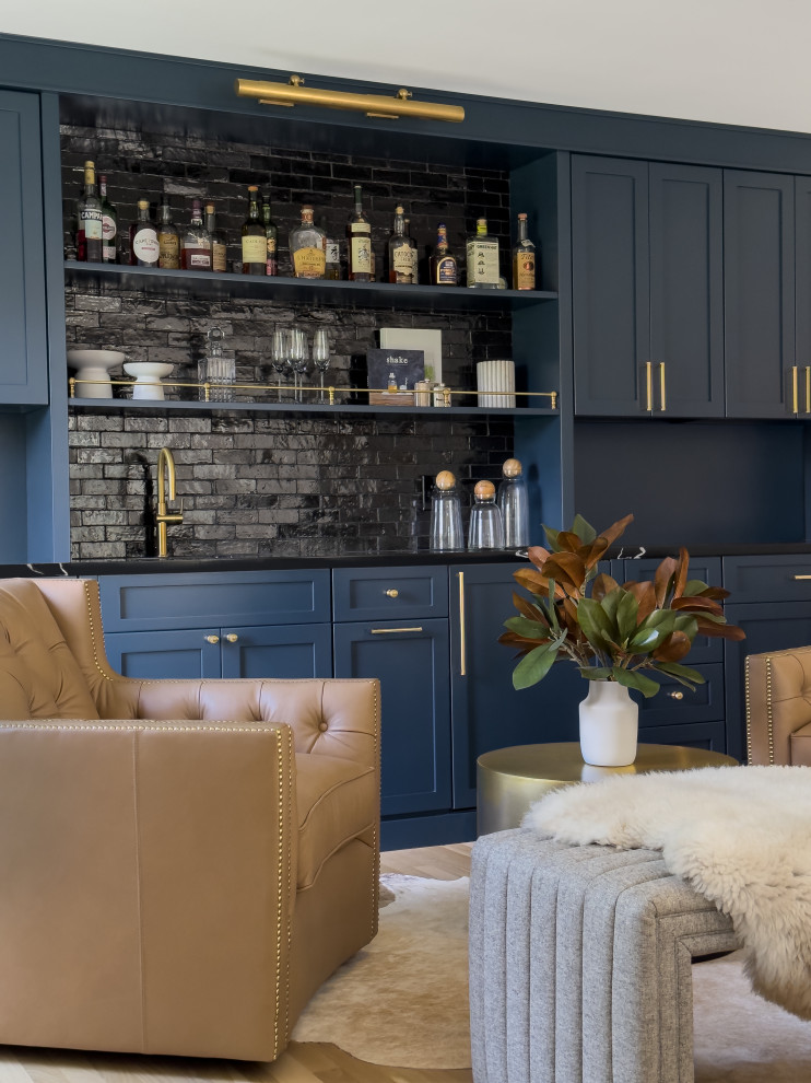 Immagine di un grande angolo bar con lavandino moderno con lavello sottopiano, ante lisce, ante blu, top in quarzo composito, paraspruzzi nero, paraspruzzi in mattoni, parquet chiaro, pavimento beige e top nero