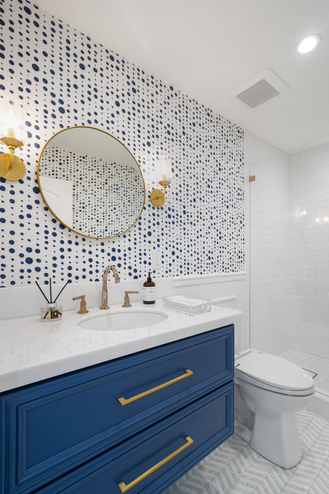 Стильный дизайн: маленькая ванная комната в стиле неоклассика (современная классика) с фасадами с выступающей филенкой, синими фасадами, душем в нише, белой плиткой, керамической плиткой, синими стенами, мраморным полом, врезной раковиной, мраморной столешницей, серым полом, душем с распашными дверями, белой столешницей, тумбой под одну раковину, подвесной тумбой и обоями на стенах для на участке и в саду - последний тренд