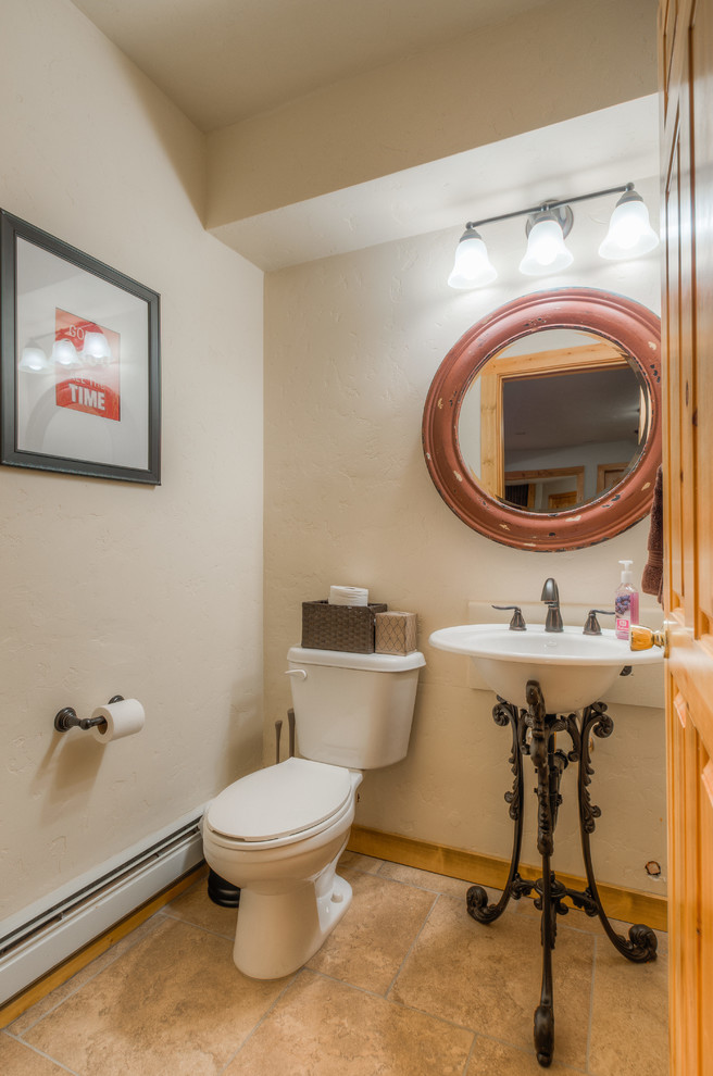 Small country powder room in Denver with a one-piece toilet, white walls, ceramic floors and a pedestal sink.