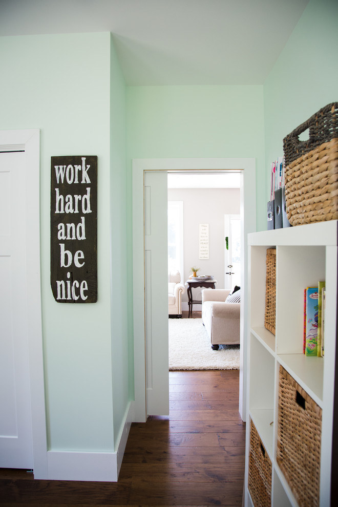 This is an example of a mid-sized country gender-neutral kids' playroom for kids 4-10 years old in Other with green walls, medium hardwood floors and brown floor.