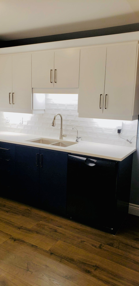 Transitional u-shaped open concept kitchen photo with an undermount sink, flat-panel cabinets, white cabinets, quartzite countertops, white backsplash, porcelain backsplash, no island and white countertops