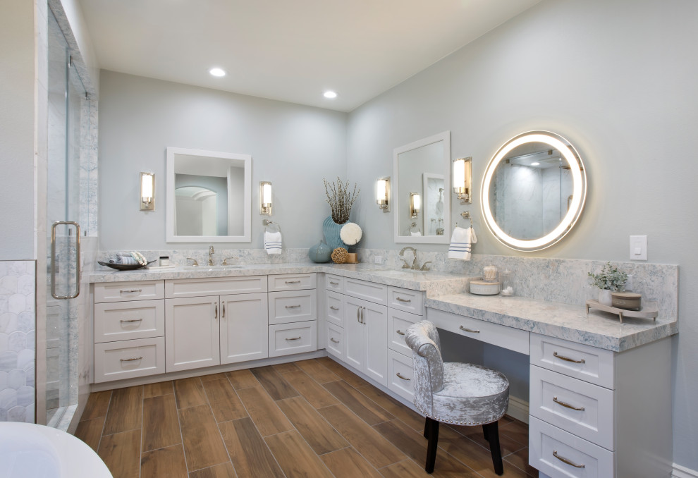 Photo of an expansive beach style master bathroom in Orange County with shaker cabinets, a freestanding tub, a double shower, a one-piece toilet, marble, an undermount sink, engineered quartz benchtops, an open shower, blue benchtops, a double vanity and a built-in vanity.
