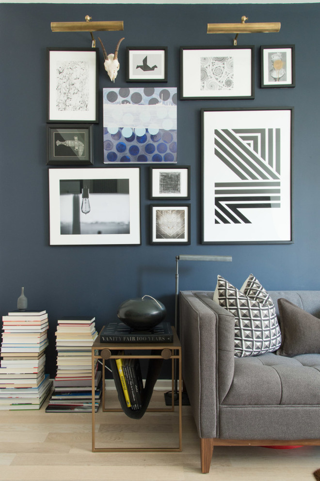 Example of a trendy light wood floor living room library design in New York with blue walls