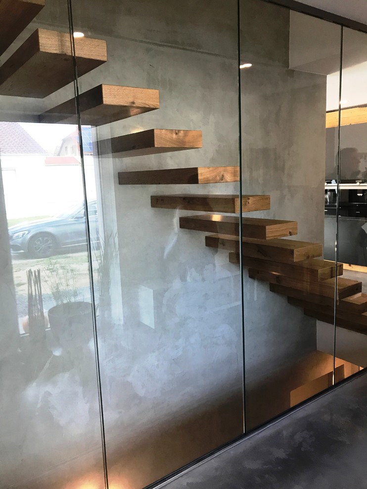 Example of a large minimalist wooden floating staircase design in Other with wooden risers