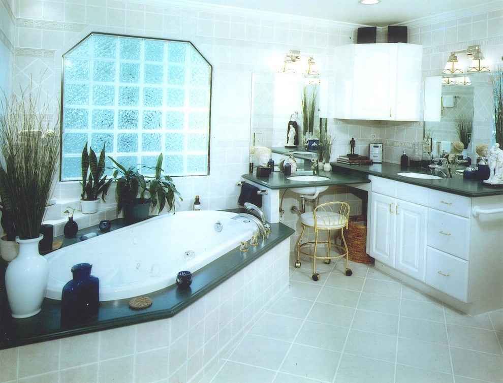 Inspiration for a large eclectic master beige tile and ceramic tile ceramic tile drop-in bathtub remodel in Charlotte with raised-panel cabinets, white cabinets, a two-piece toilet, beige walls, a wall-mount sink and solid surface countertops