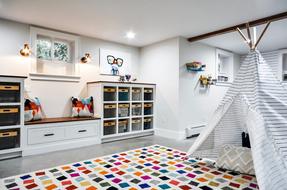 This is an example of a large transitional gender-neutral kids' playroom for kids 4-10 years old in Newark with white walls, concrete floors and grey floor.