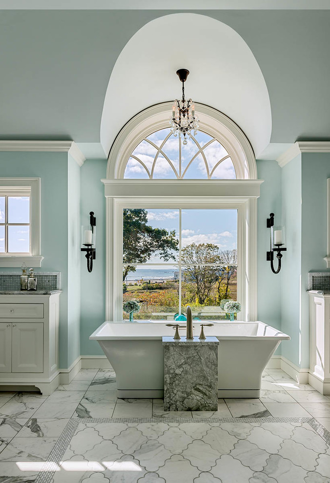 Photo of a traditional master bathroom in Boston with recessed-panel cabinets, white cabinets, a freestanding tub, gray tile, mosaic tile, blue walls, white floor and grey benchtops.