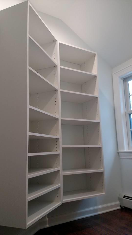 This is an example of a mid-sized modern walk-in wardrobe in Other with white cabinets and medium hardwood floors.