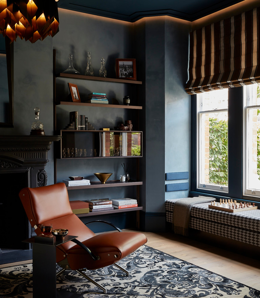 This is an example of a mid-sized home office in London with blue walls and a corner fireplace.