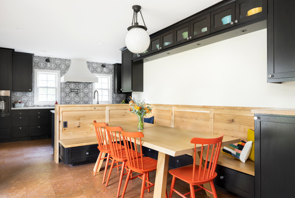 Photo of a transitional galley eat-in kitchen in Portland with a farmhouse sink, shaker cabinets, black cabinets, quartz benchtops, multi-coloured splashback, terra-cotta splashback, black appliances, cork floors, no island, brown floor and white benchtop.