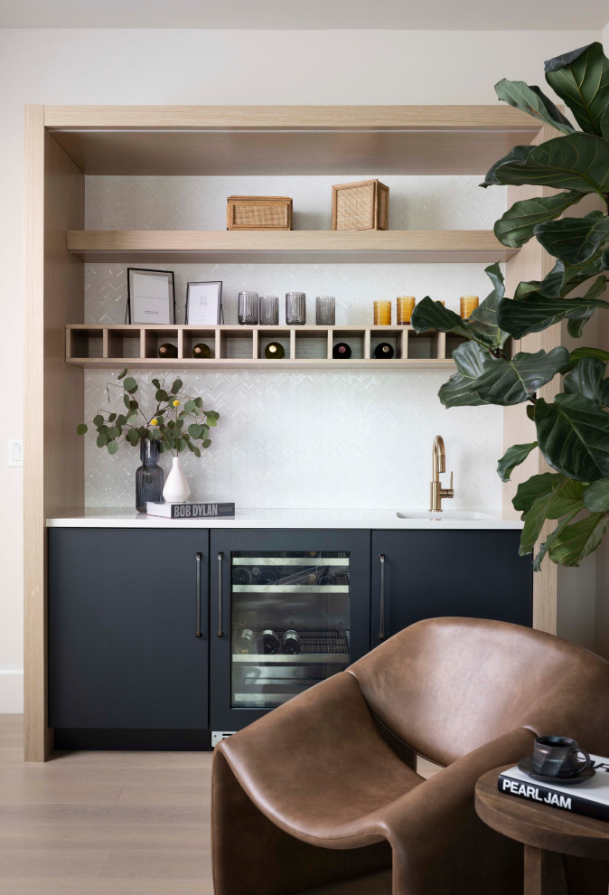 Wet bar - contemporary light wood floor and beige floor wet bar idea in Miami with an undermount sink, flat-panel cabinets, black cabinets, white backsplash, mosaic tile backsplash and white countertops