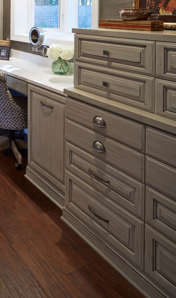 Photo of a mid-sized traditional gender-neutral dressing room in Jacksonville with raised-panel cabinets, grey cabinets and medium hardwood floors.