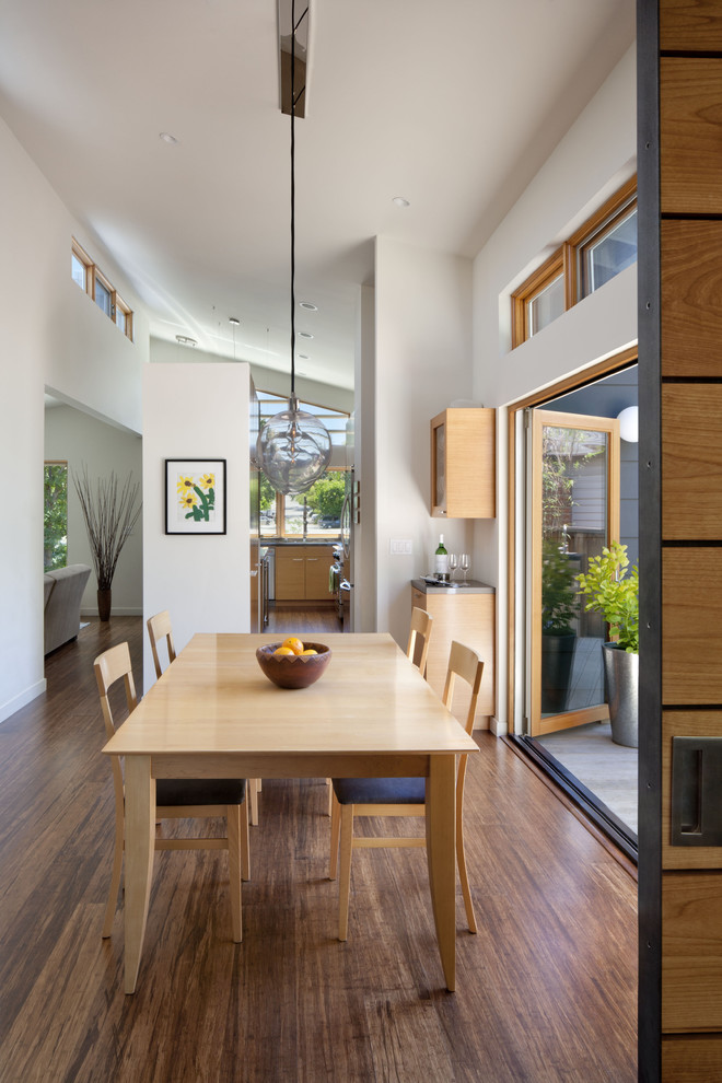 Photo of a modern kitchen/dining combo in San Francisco with white walls, medium hardwood floors and no fireplace.