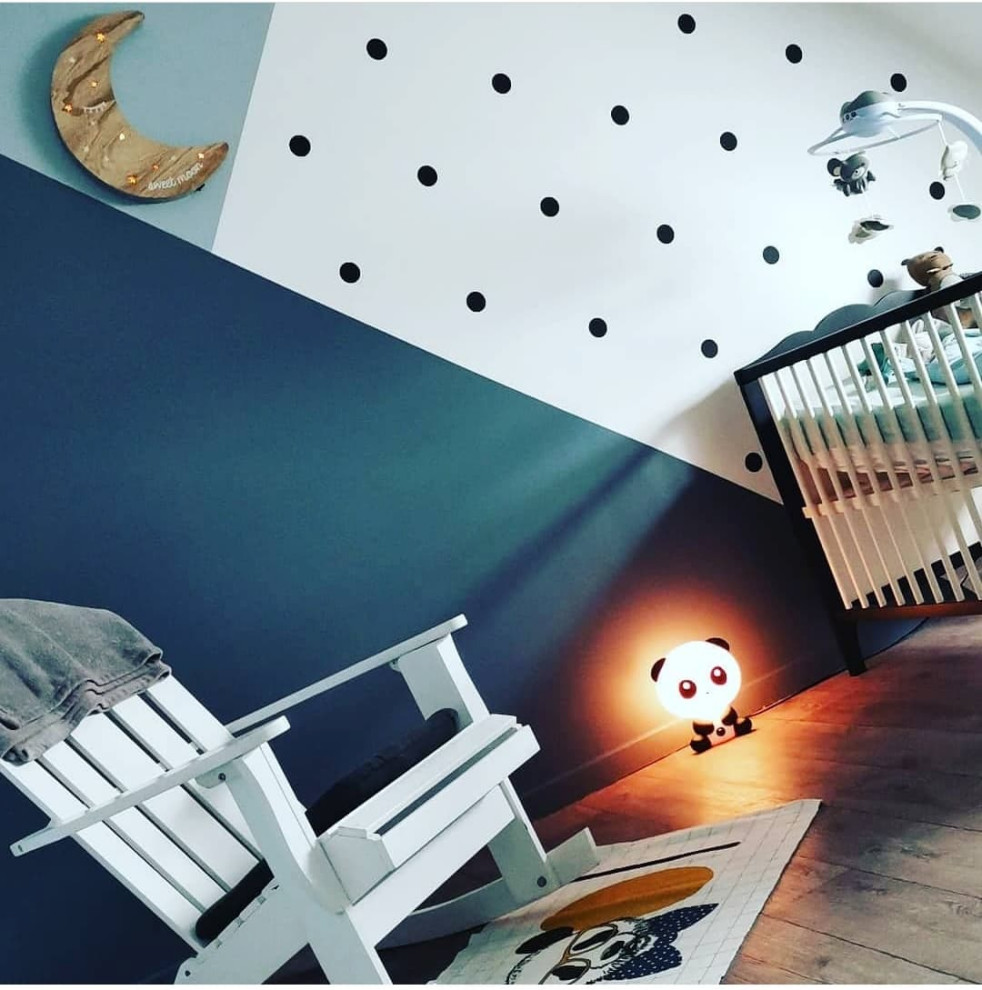 This is an example of a small contemporary gender neutral toddler’s room in Rennes with grey walls and lino flooring.
