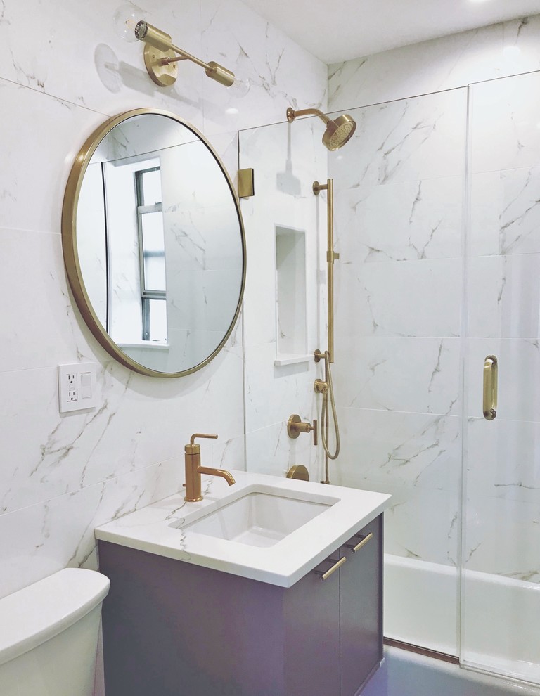 Design ideas for a mid-sized contemporary 3/4 bathroom in New York with flat-panel cabinets, grey cabinets, an alcove tub, a shower/bathtub combo, a two-piece toilet, white tile, marble, white walls, a wall-mount sink, marble benchtops, a hinged shower door and white benchtops.