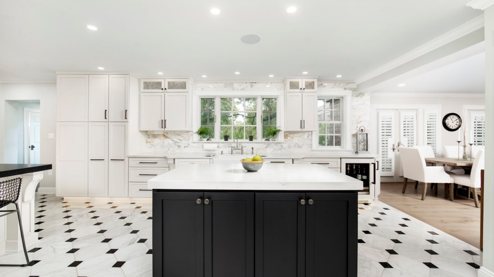 Huge porcelain tile and white floor eat-in kitchen photo with an undermount sink, shaker cabinets, white cabinets, quartz countertops, white backsplash, ceramic backsplash, stainless steel appliances, two islands and white countertops