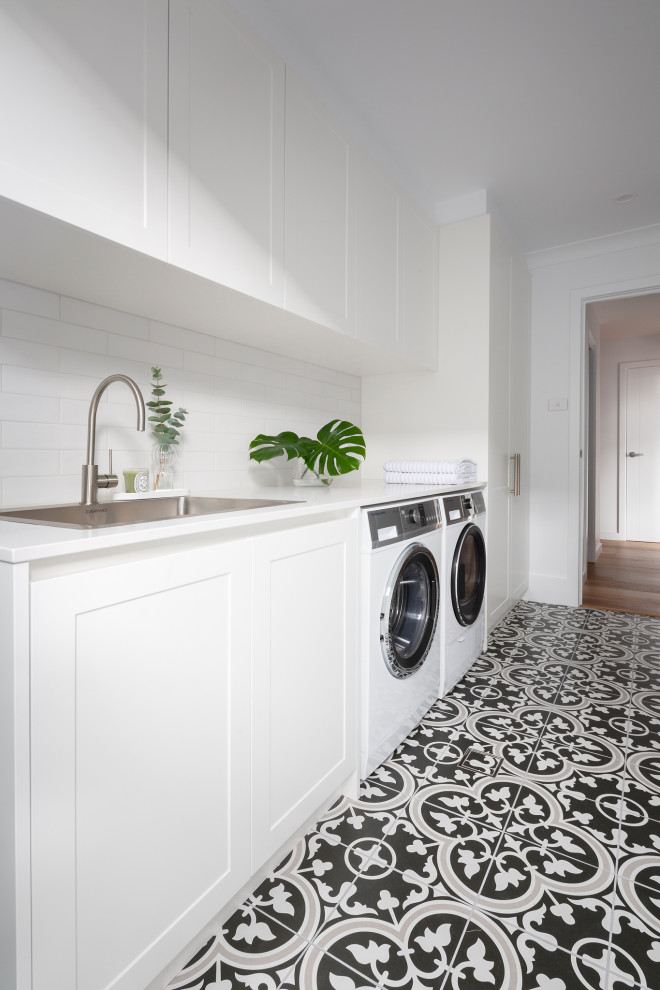 This is an example of a modern laundry room in Canberra - Queanbeyan with white splashback, subway tile splashback, porcelain floors and blue floor.