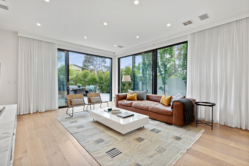 Large contemporary open concept living room in Melbourne with white walls, medium hardwood floors, no fireplace and brown floor.