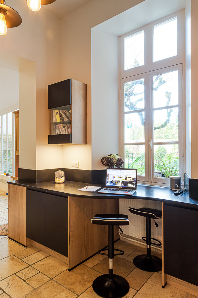 Photo of an expansive urban open plan kitchen with black cabinets, black appliances and beige floors.