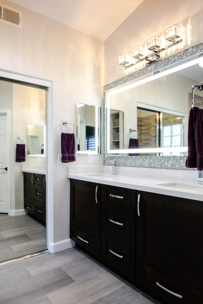 Photo of a mid-sized contemporary master bathroom in Phoenix with shaker cabinets, dark wood cabinets, a double shower, beige tile, ceramic tile, beige walls, laminate floors, an undermount sink, engineered quartz benchtops, beige floor and a hinged shower door.