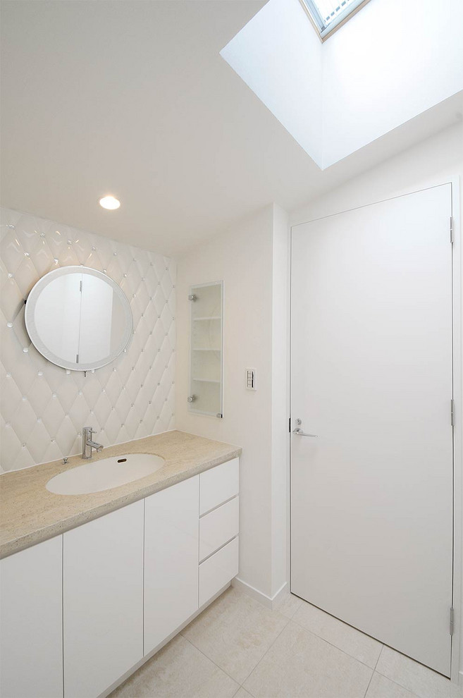 Traditional powder room with white cabinets, white tile, white walls, an undermount sink, beige floor and beige benchtops.