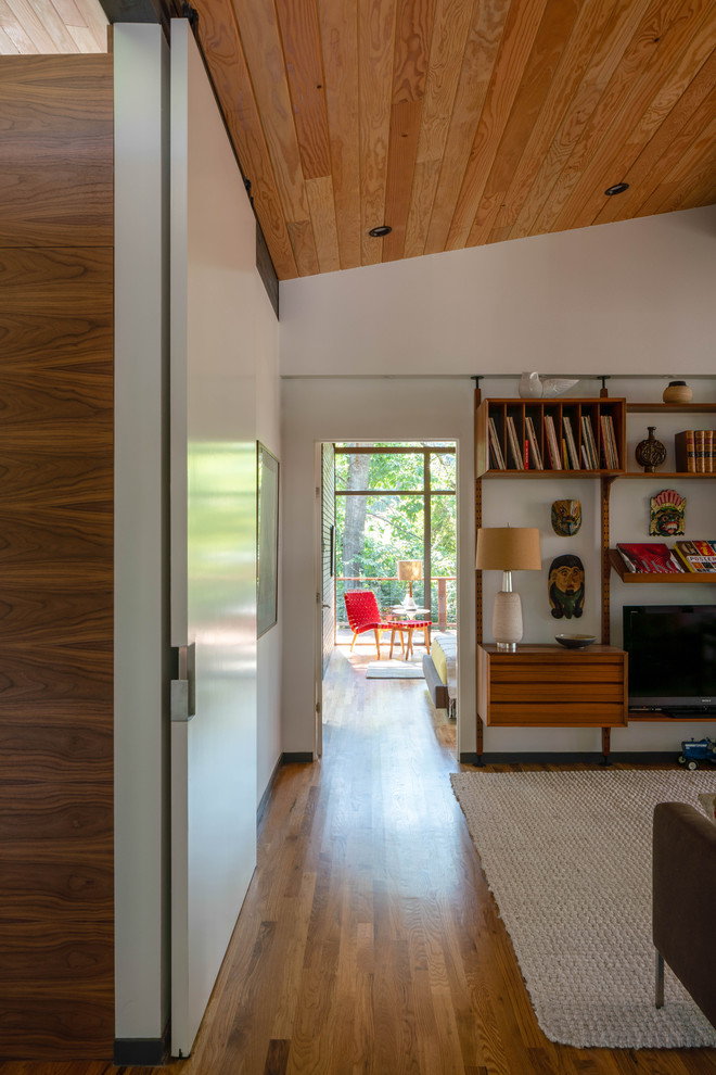 Inspiration for a small midcentury open concept family room in Dallas with white walls and light hardwood floors.