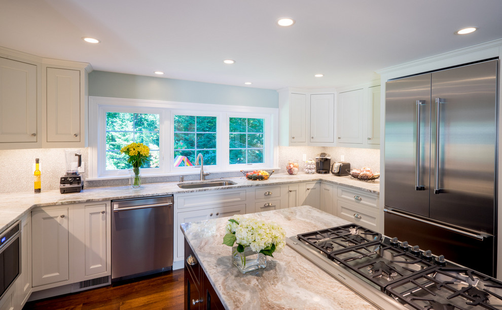 Mid-sized transitional u-shaped open plan kitchen in Boston with an undermount sink, beaded inset cabinets, white cabinets, quartzite benchtops, white splashback, glass sheet splashback, stainless steel appliances, dark hardwood floors and with island.