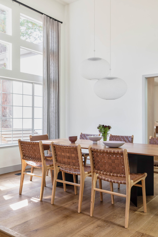 Esempio di una grande sala da pranzo aperta verso la cucina contemporanea con pareti bianche, parquet chiaro e pavimento marrone