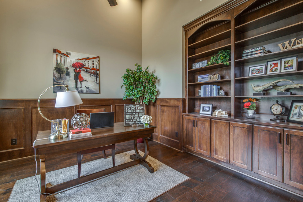 This is an example of a large mediterranean study room in Houston with beige walls, dark hardwood floors, no fireplace, a freestanding desk and brown floor.
