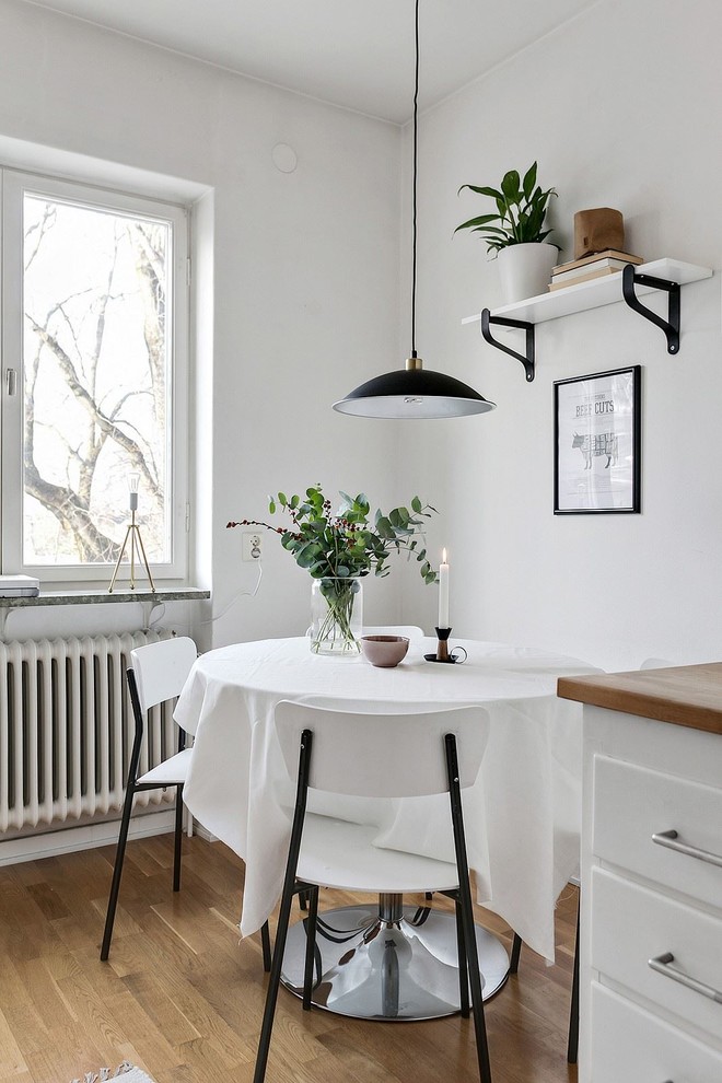 Design ideas for a scandinavian dining room with white walls, medium hardwood floors and beige floor.