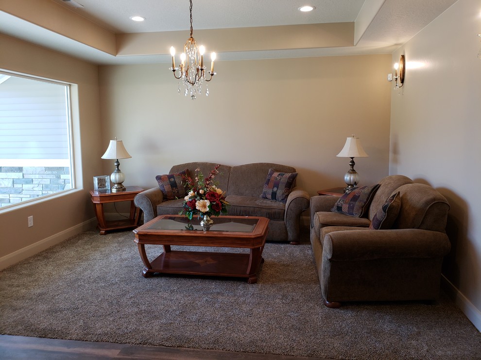 Mid-sized traditional enclosed living room in Other with beige walls, carpet and brown floor.