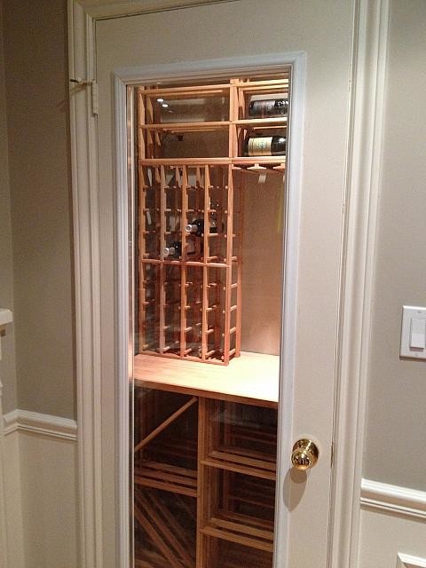 Inspiration for a mid-sized contemporary wine cellar in Toronto with medium hardwood floors, storage racks and brown floor.