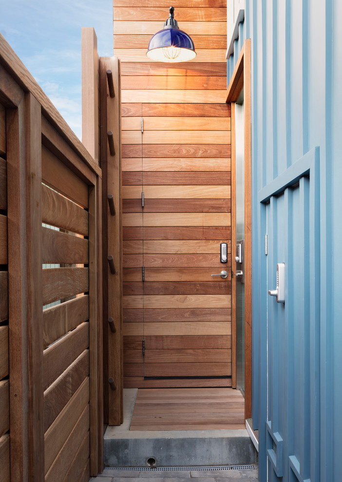Inspiration for a beach style front door in San Francisco with blue walls, a single front door, a medium wood front door and grey floor.