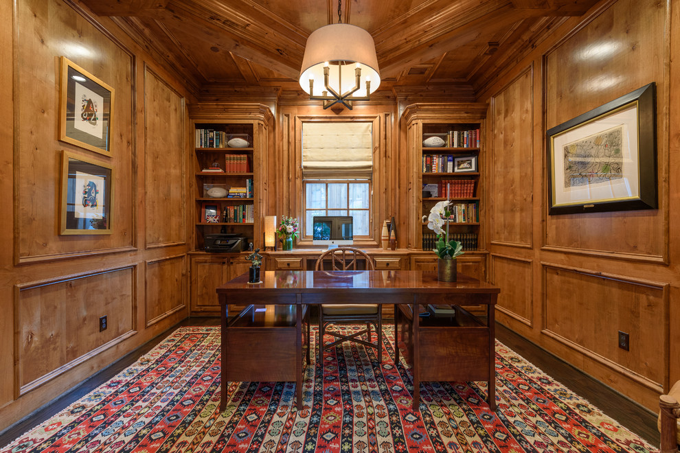 This is an example of a large traditional study room in Dallas with brown walls, dark hardwood floors, no fireplace, a freestanding desk and brown floor.