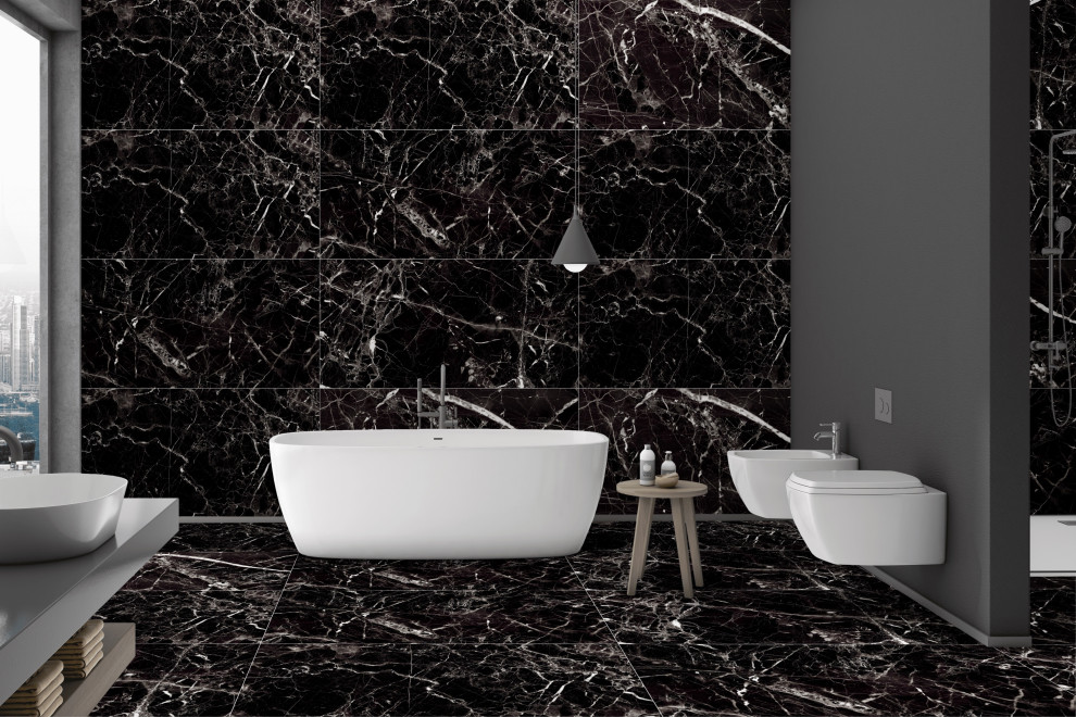 Modelo de cuarto de baño gris y negro de tamaño medio con bañera exenta, baldosas y/o azulejos de porcelana, paredes negras y encimera de azulejos