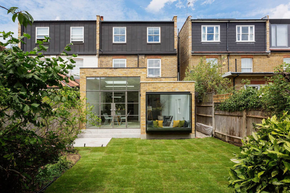 Inspiration for a mid-sized modern three-storey brick multi-coloured duplex exterior in London with a flat roof, a metal roof and a black roof.