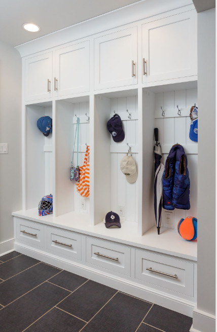 Design ideas for a mid-sized transitional mudroom in Philadelphia with white walls, laminate floors and black floor.