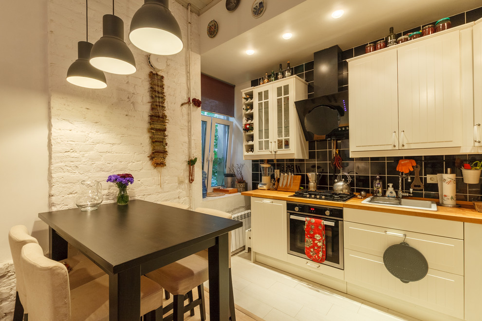 Design ideas for a contemporary l-shaped open plan kitchen in Saint Petersburg with a drop-in sink, white cabinets, black splashback and black appliances.