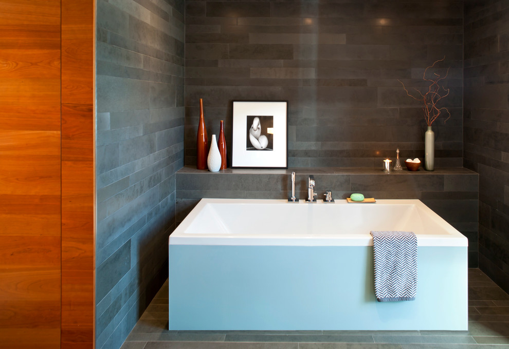 Photo of a modern bathroom in Vancouver with a freestanding tub and gray tile.