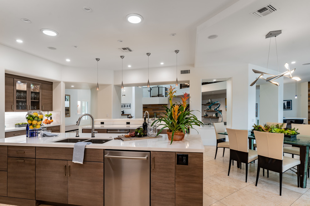 Photo of a large modern l-shaped eat-in kitchen in Minneapolis with an undermount sink, flat-panel cabinets, grey cabinets, quartz benchtops, white splashback, ceramic splashback, stainless steel appliances, travertine floors, multiple islands, beige floor and white benchtop.