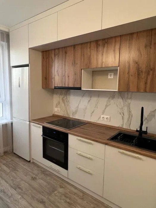 Photo of a mid-sized contemporary single-wall eat-in kitchen in Moscow with a single-bowl sink, flat-panel cabinets, white cabinets, wood benchtops, white splashback, marble splashback, panelled appliances, laminate floors, no island, beige floor and brown benchtop.