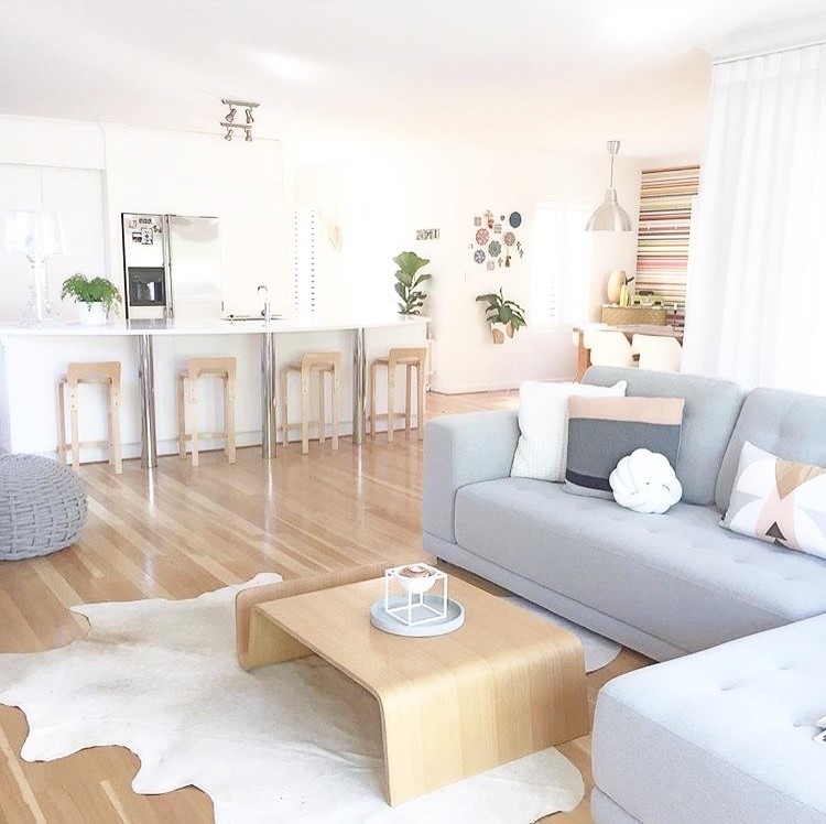 This is an example of a scandinavian open concept living room in Perth with white walls, light hardwood floors and a wall-mounted tv.