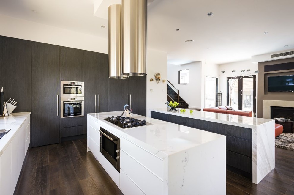 This is an example of a large contemporary open plan kitchen in Other with flat-panel cabinets, dark wood cabinets, stainless steel appliances, dark hardwood floors and brown floor.