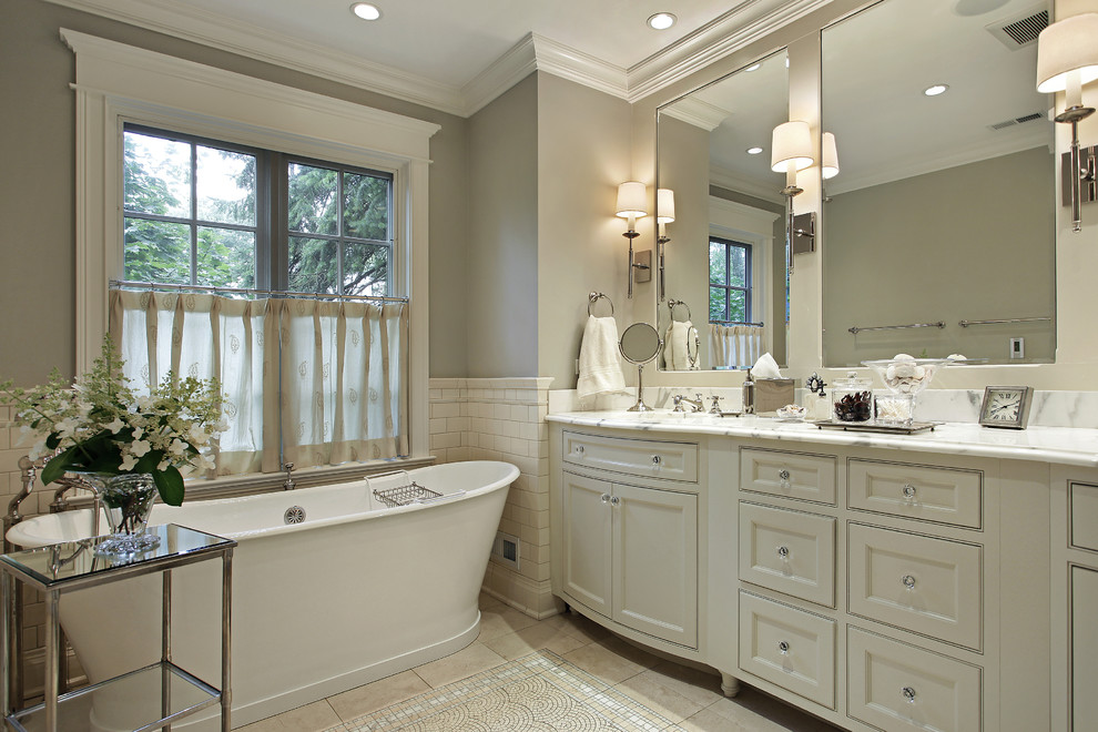 This is an example of a large traditional master bathroom in Los Angeles with flat-panel cabinets, white cabinets, a freestanding tub, white tile, subway tile, white walls, mosaic tile floors, an undermount sink and marble benchtops.