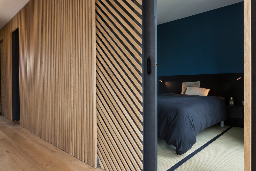Inspiration for a mid-sized contemporary master bedroom in Paris with blue walls, tatami floors, no fireplace and white floor.