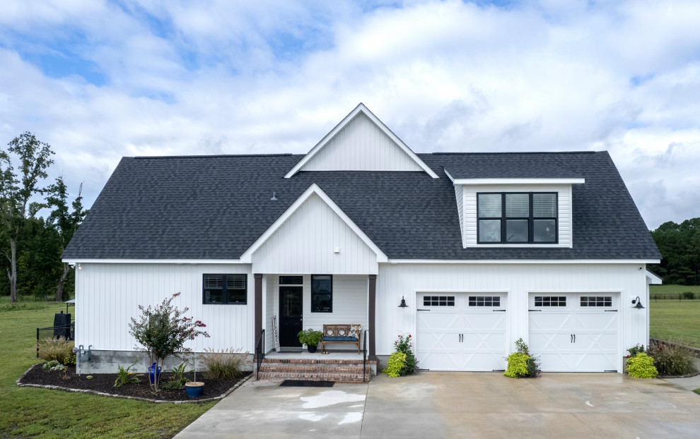 Einstöckiges Landhausstil Einfamilienhaus mit Mix-Fassade, weißer Fassadenfarbe, Satteldach, Schindeldach, grauem Dach und Wandpaneelen in Sonstige